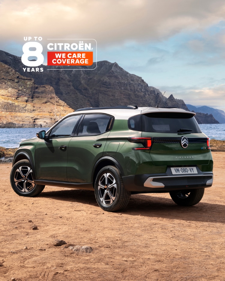 Rear three‑quarter seaside view of Citroën ë‑C3 Aircross electric SUV highlighting award‑winning design and 8‑year coverage for affordable mobility.