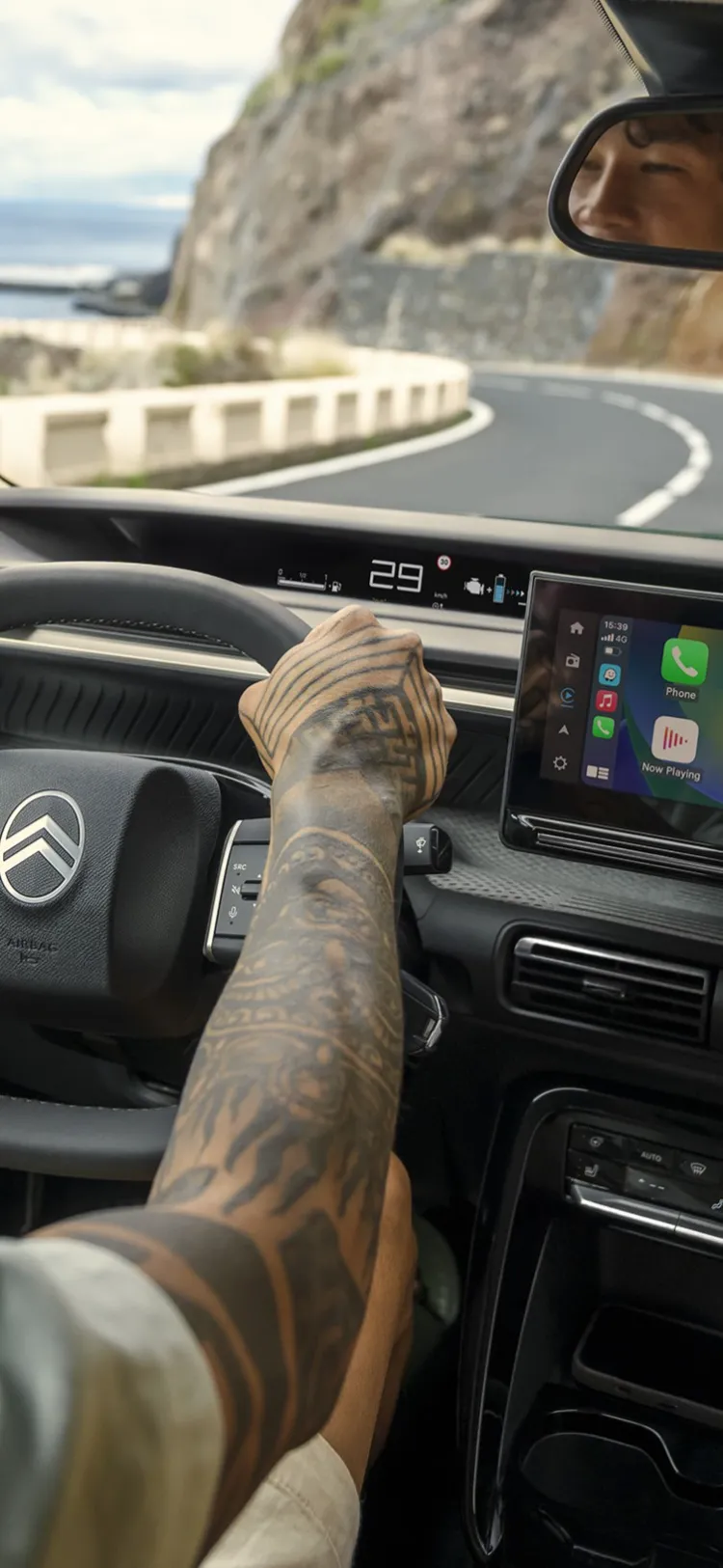 Driver‑view of Citroën C3 Aircross SUV showing large infotainment screen for intuitive, connected and affordable everyday driving on coastal roads.